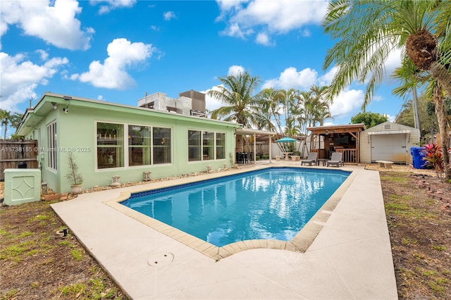 view of swimming pool featuring a patio area and a storage unit