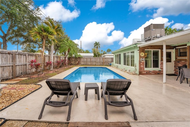 view of pool featuring a patio area and central air condition unit