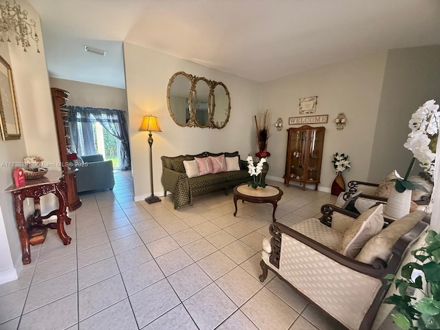 living area featuring light tile patterned floors, visible vents, and baseboards