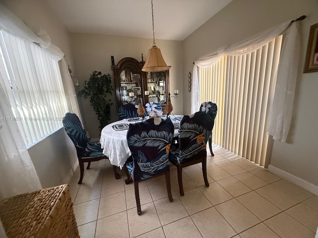 dining room featuring a healthy amount of sunlight, light tile patterned floors, and baseboards