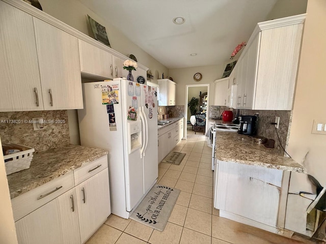 kitchen featuring backsplash, white appliances, light stone counters, and light tile patterned floors