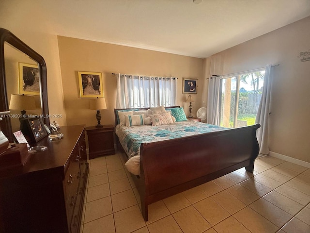 bedroom with light tile patterned floors, access to exterior, and baseboards