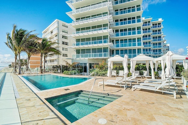 view of pool with a patio area and a hot tub