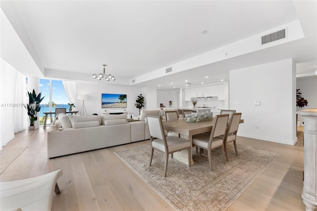 dining space with a chandelier and light hardwood / wood-style flooring