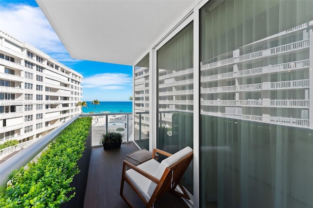 balcony with a water view and a beach view