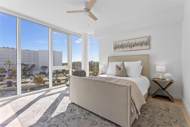 bedroom with expansive windows and ceiling fan