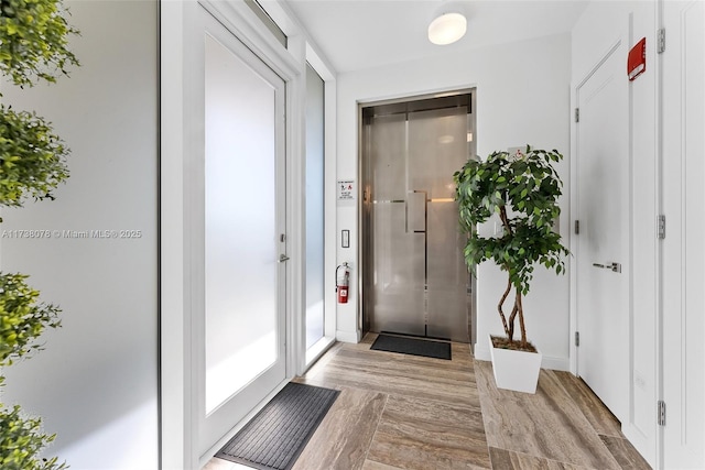 entryway featuring elevator and light wood-type flooring