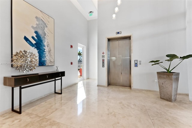 hallway with a high ceiling and elevator