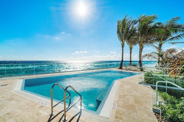 view of pool featuring a patio area and a water view