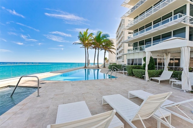 view of swimming pool featuring a patio area and a water view