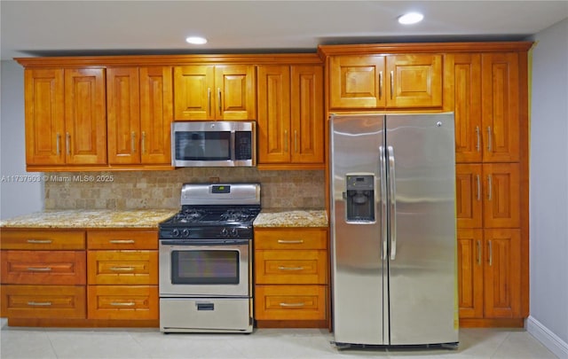 kitchen featuring light stone counters, appliances with stainless steel finishes, and backsplash