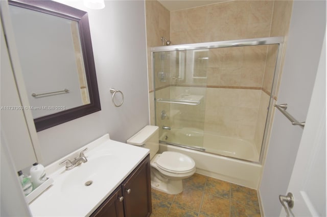 full bathroom with enclosed tub / shower combo, vanity, and toilet