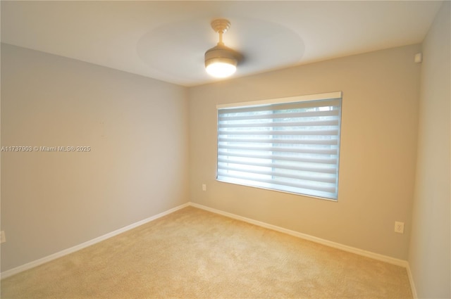 carpeted spare room with ceiling fan