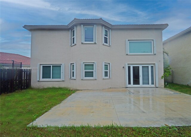 rear view of house featuring a patio and a lawn