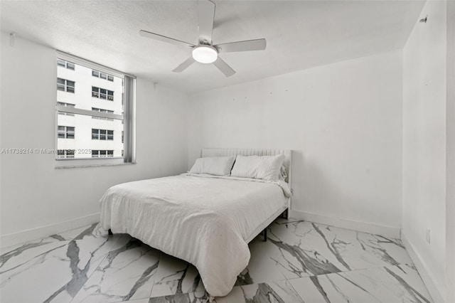 bedroom featuring ceiling fan and a textured ceiling