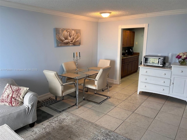 tiled dining area with crown molding, sink, and a textured ceiling