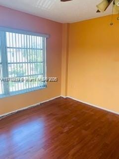 empty room featuring ceiling fan and dark hardwood / wood-style flooring