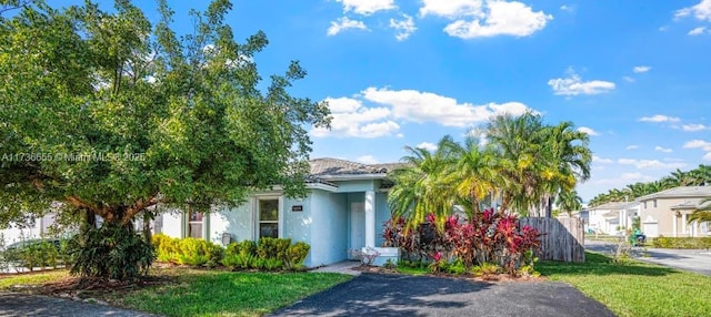 view of property hidden behind natural elements featuring a front lawn