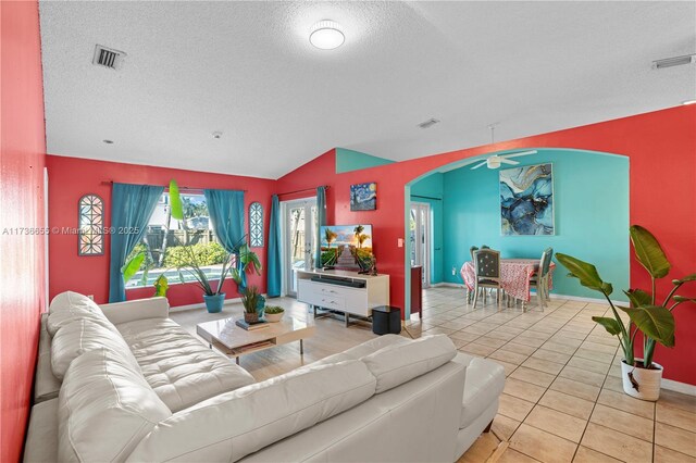 living room featuring vaulted ceiling, a textured ceiling, and light hardwood / wood-style floors