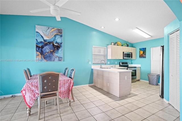 kitchen featuring lofted ceiling, appliances with stainless steel finishes, and light tile patterned floors