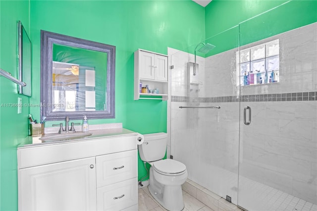 bathroom featuring vanity, toilet, and a shower with shower door