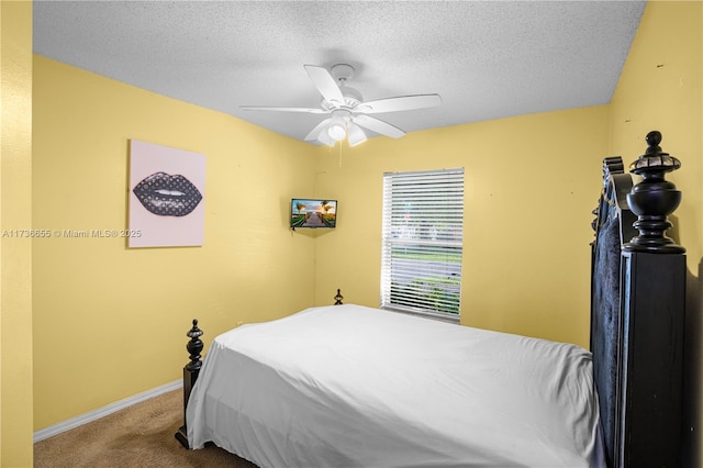 carpeted bedroom featuring ceiling fan and a textured ceiling