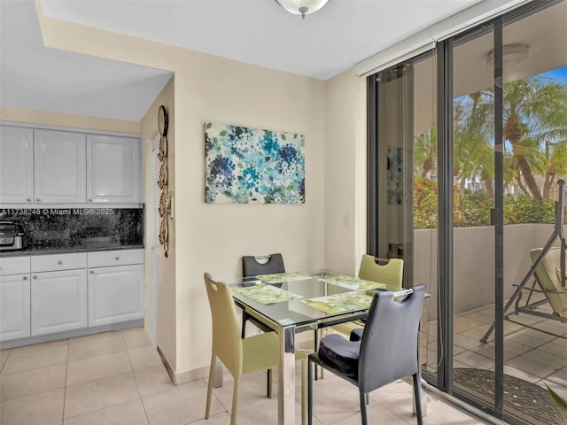 dining area featuring light tile patterned floors and baseboards