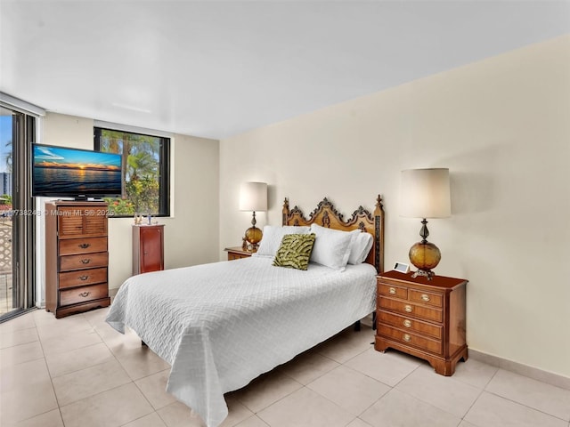 bedroom with baseboards and light tile patterned floors