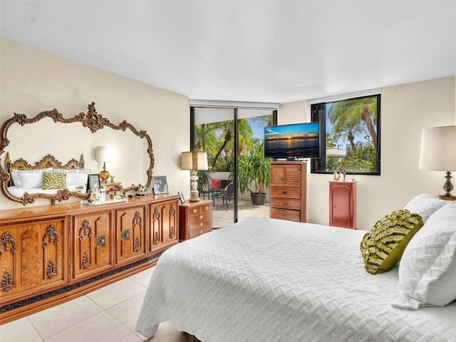 bedroom featuring light tile patterned floors, access to outside, and expansive windows