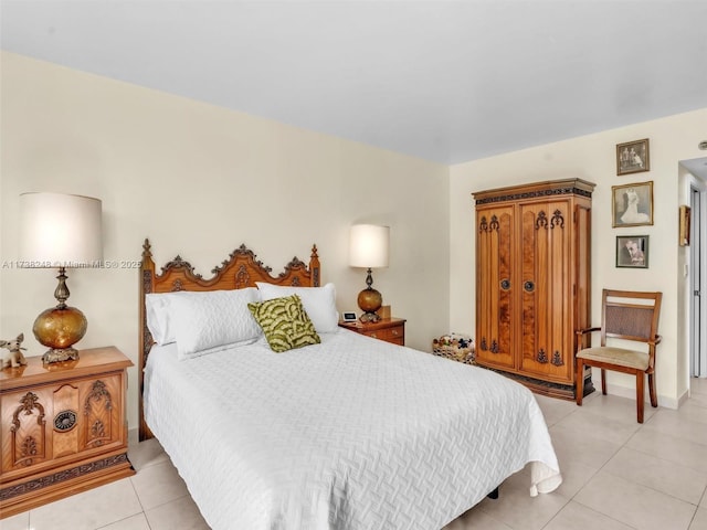 bedroom with light tile patterned floors and baseboards