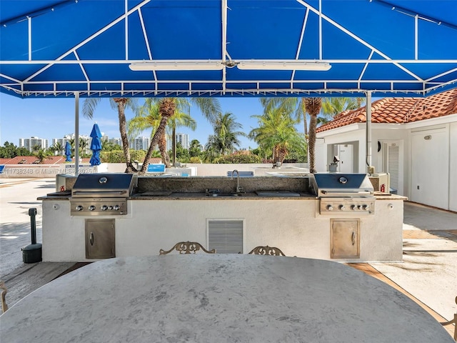 view of patio featuring area for grilling, a sink, visible vents, and an outdoor kitchen