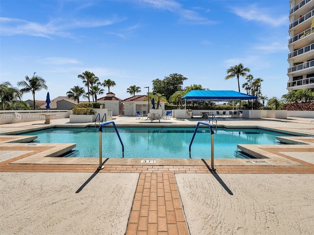 pool with a patio and fence