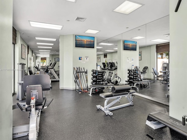 workout area featuring a healthy amount of sunlight, visible vents, and baseboards