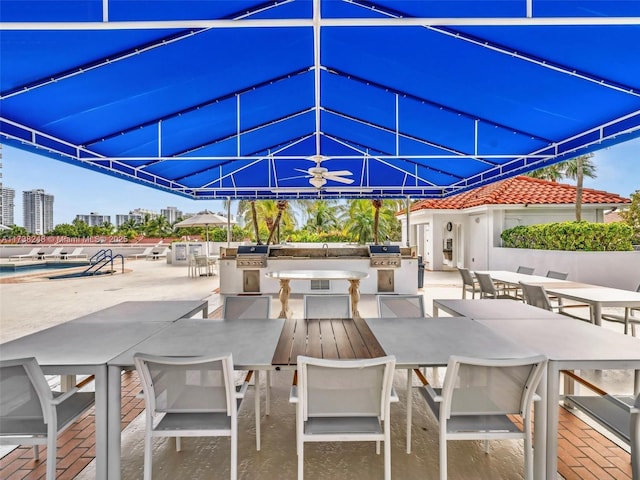 view of patio / terrace featuring an outdoor kitchen, a community pool, and a city view