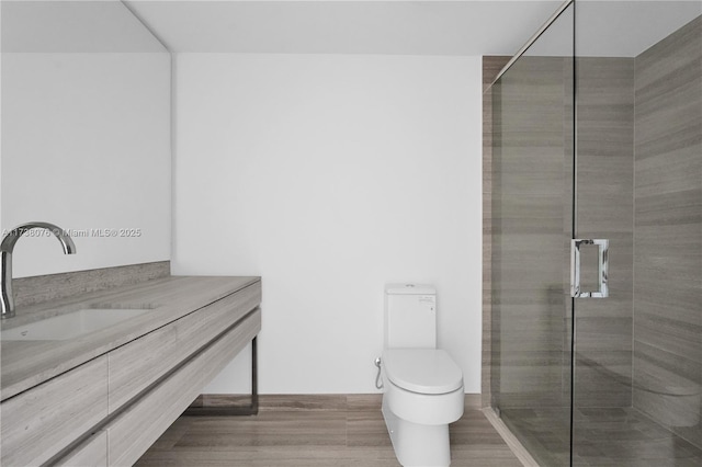 bathroom featuring vanity, a shower with shower door, and toilet