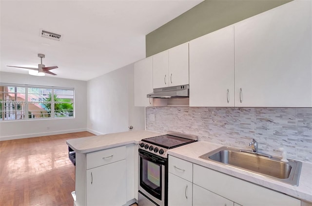 kitchen featuring stainless steel range with electric stovetop, sink, kitchen peninsula, and white cabinets