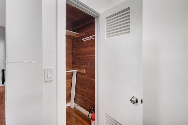 bathroom with wooden walls and hardwood / wood-style floors