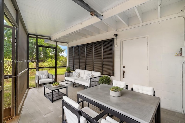 sunroom with vaulted ceiling with beams