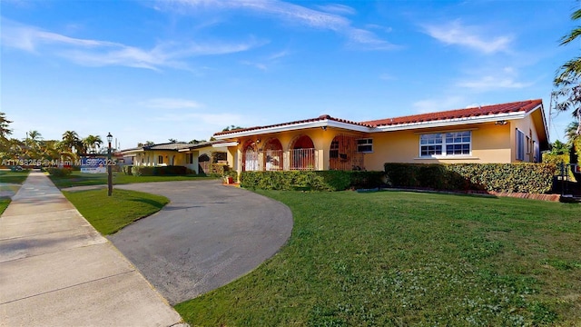 mediterranean / spanish house with a front lawn