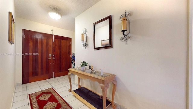 foyer entrance with light tile patterned floors and a textured ceiling