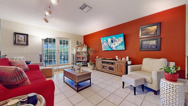 living room with french doors, rail lighting, a textured ceiling, and light tile patterned floors