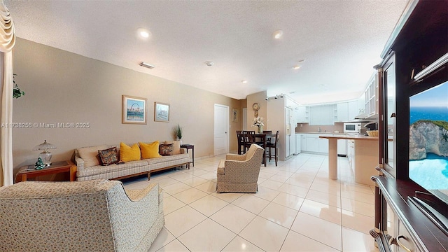 living room with light tile patterned flooring and a textured ceiling