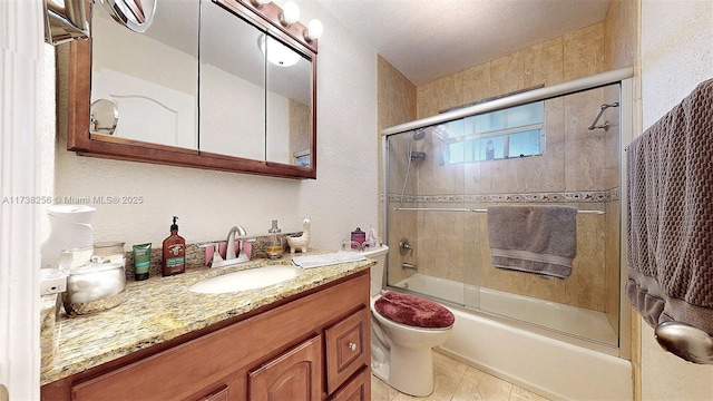 full bathroom with tile patterned floors, vanity, toilet, and combined bath / shower with glass door
