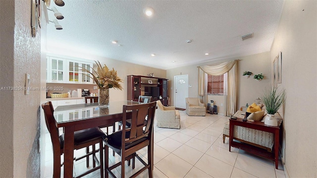tiled dining area with a textured ceiling