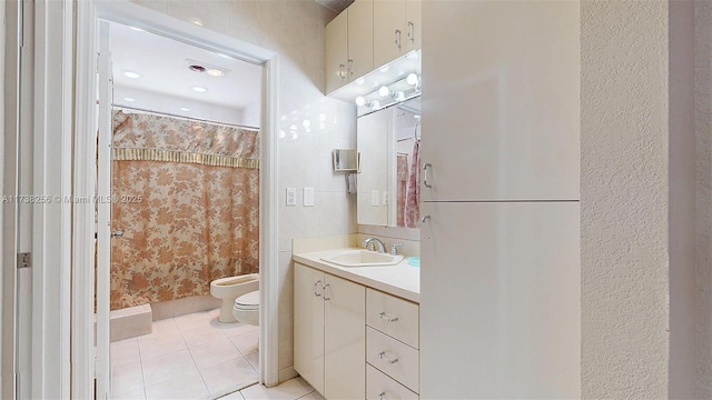 bathroom with tile patterned floors, toilet, a shower with curtain, a bidet, and vanity