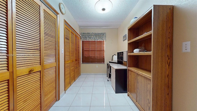 hallway featuring light tile patterned floors and a textured ceiling