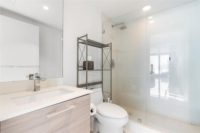 bathroom featuring toilet, vanity, and walk in shower