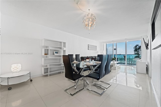 dining area with a chandelier, expansive windows, baseboards, and light tile patterned floors