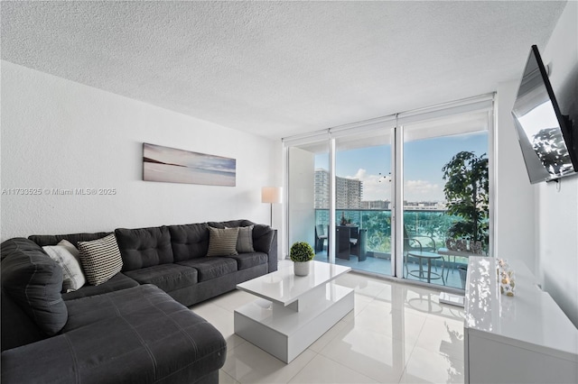 living area featuring expansive windows, a textured ceiling, and light tile patterned flooring