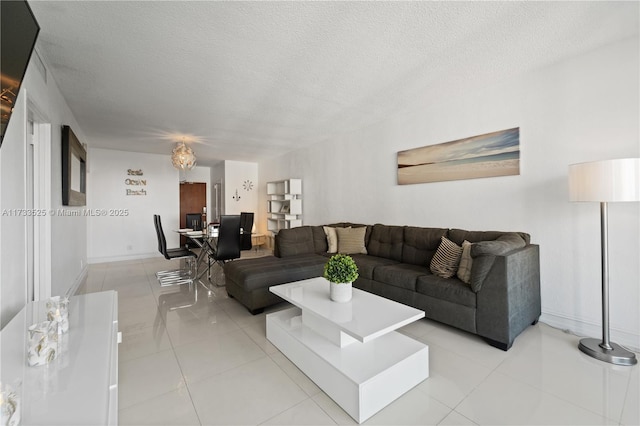 living area featuring a textured ceiling, baseboards, and light tile patterned floors